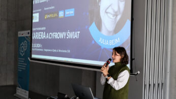 Kobieta w zielonej kamizelce przemawia do mikrofonu na podium przed ekranem projekcyjnym wyświetlającym szczegóły wydarzenia i zdjęcie Julii Bejm. W tle widać szarą ścianę i kolorowy plakat po lewej stronie.
