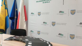 Stół konferencyjny z teczkami i tabliczką z napisem 
