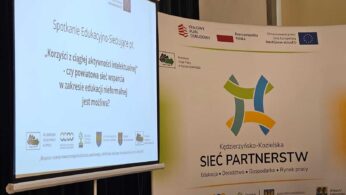 Na ekranie projektora wyświetlana jest prezentacja zatytułowana Korzyści z ciągłej aktywności intelektualnej, obok dużego stojącego banera z logo i kolorowymi połączonymi kształtami, promującego sieć partnerską na rzecz edukacji i rynku pracy w Kędzierzynie-Koźlu.