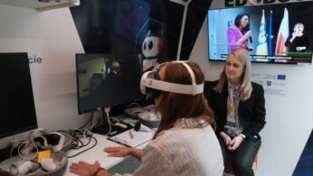 Kobieta z goglami VR siedzi przy biurku wewnątrz vana 