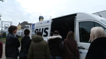 Grupa uczniów wchodzi do środka EDUBUSA