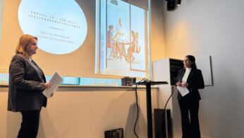 Dwie kobiety prowadzą prezentację w jasnej, nowoczesnej sali konferencyjnej. Na ekranie projekcyjnym wyświetlony jest slajd z nagłówkiem po szwedzku: 