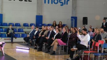 Ujęcie z sali konferencyjnej, która wygląda jak hala sportowa, z widocznym napisem 