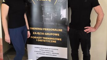 Kobieta i mężczyzna w sportowych strojach stoją obok dużego banera reklamowego 