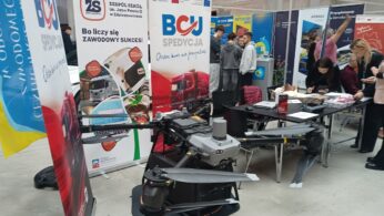 zbliżenie na dron, będący ekspozycją w przestronnej hali wystawowej, wypełnionej młodzieżą oraz wystawcami – przedstawicielami pracodawców, szkół, uczelni.