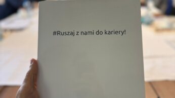 Osoba trzyma kartkę z napisem w trakcie warsztatów.
