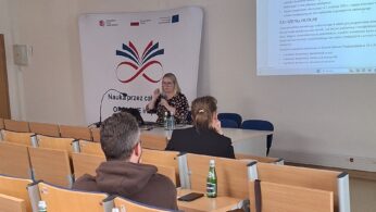 Prelegentka prowadząca prezentację w sali konferencyjnej przed uczestnikami wydarzenia