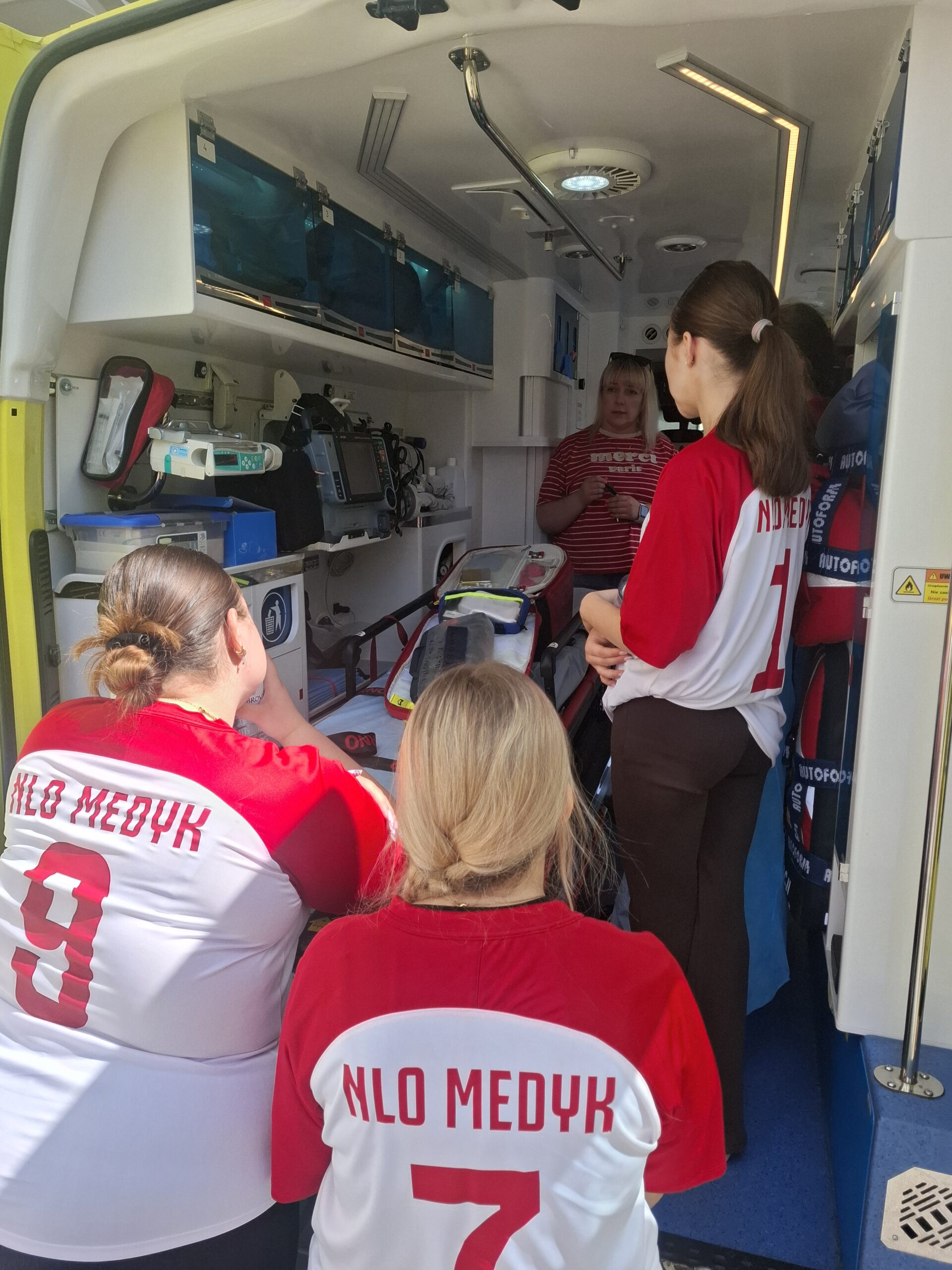 Uczestnicy szkolenia oglądający wyposażenie wnętrza ambulansu ratunkowego
