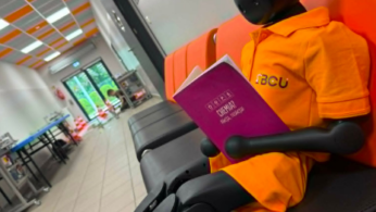 Stanowisko szkoleniowe z robotem humanoidalnym ubranym w pomarańczową koszulkę z logo BCU.