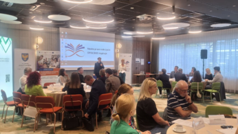 Uczestnicy wydarzenia biorą udział w prezentacji i dyskusji w nowoczesnej sali szkoleniowej.