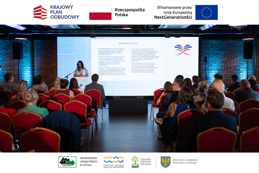 Widok z tyłu sali konferencyjnej na scenę, na której kobieta przemawia zza mównicy obok wielkiego ekranu wyświetlającego slajd „WYBRANE WNIOSKI”. Słuchacze siedzą na krzesłach z czerwonymi obiciami, skierowani w stronę prezentacji. Całość kompozycji dopełniają górne i dolne białe panele zawierające logotypy Krajowego Planu Odbudowy oraz instytucji partnerskich.